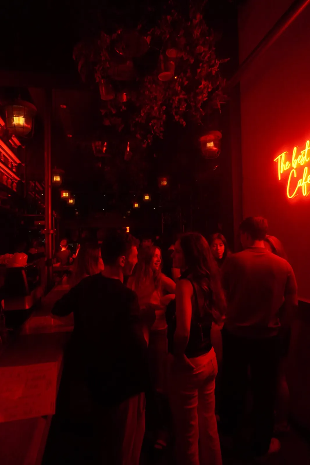 Guests talking beneath the neon sign