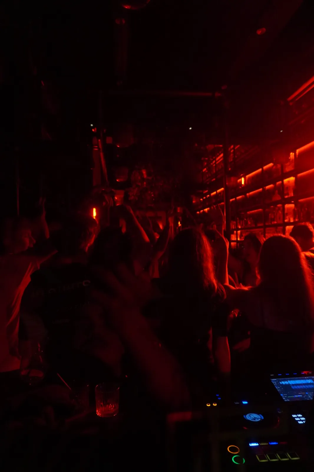 Crowd with hands up near the DJ booth